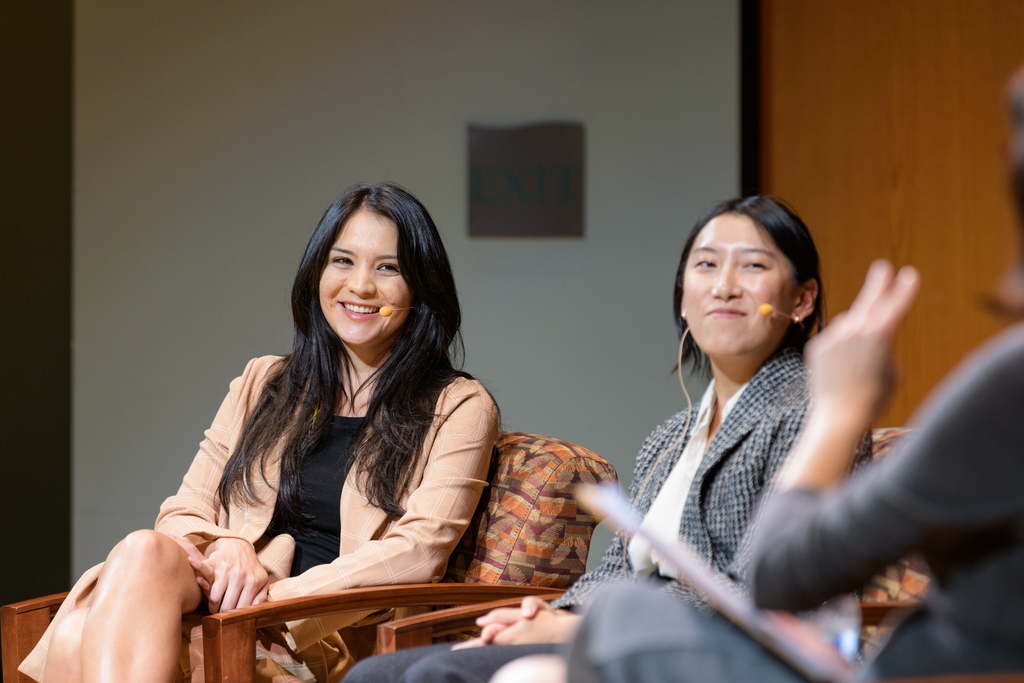 three people sitting on stage