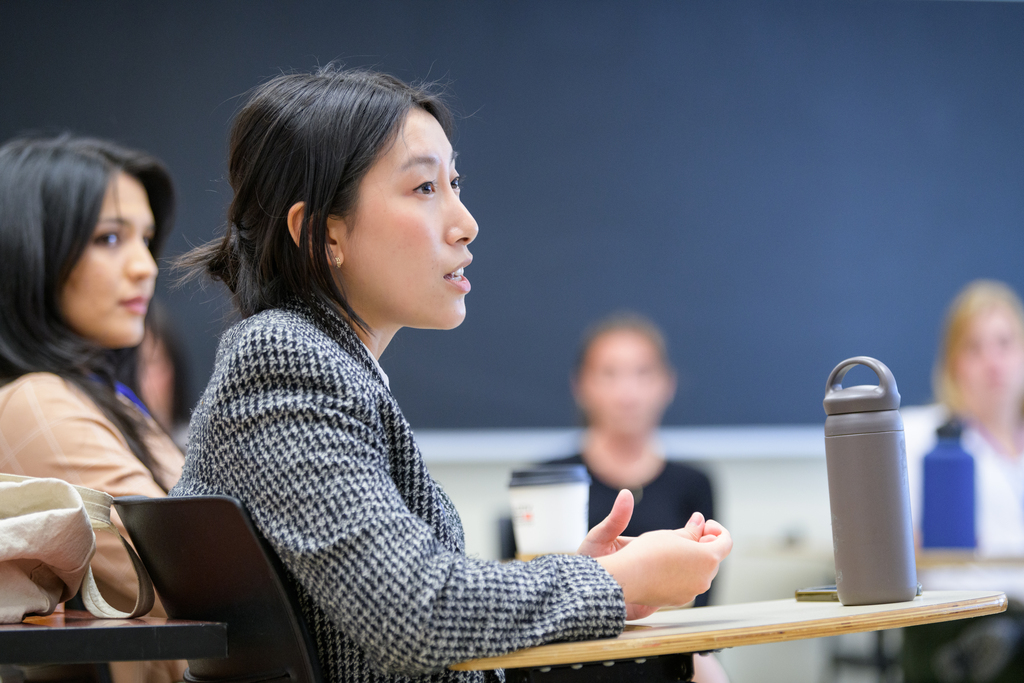 woman seated at desk speaking